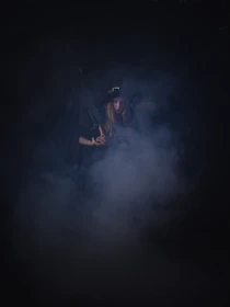 A mysterious character cloaked in shadows, hinting at a complex backstory.