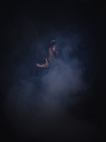 A dark, atmospheric scene featuring a mysterious character in a shadowy environment.