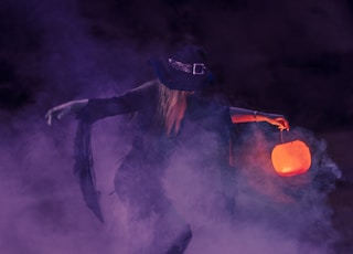 woman in black long sleeve shirt and black hat standing on black smoke