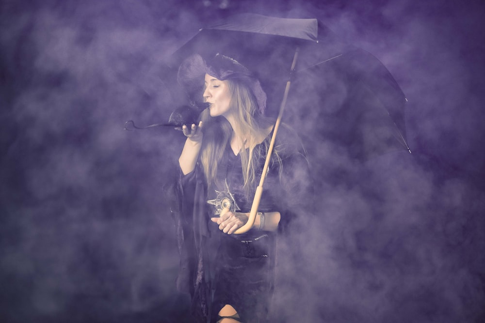 woman in black dress singing on stage