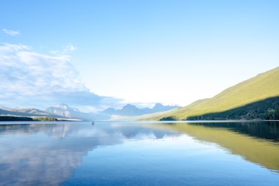 lake in the middle of mountains during daytime
