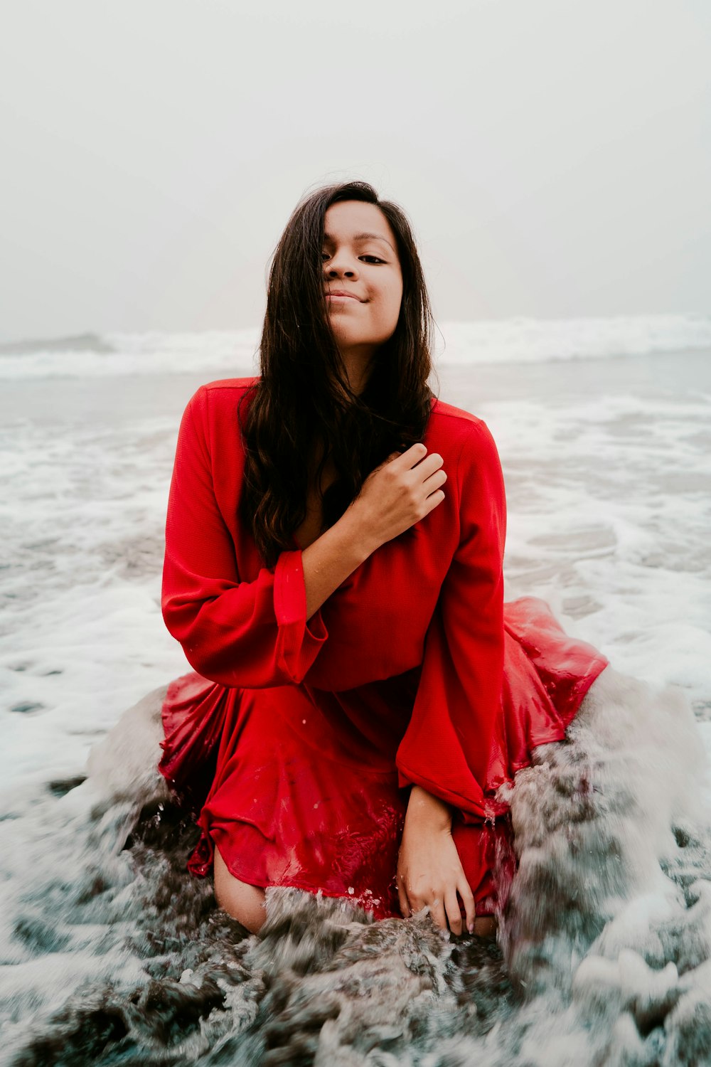 woman in red long sleeve shirt standing on snow covered ground during daytime