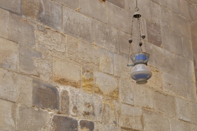 Artisan crafting a detailed iron lamp, showcasing skilled metalwork.