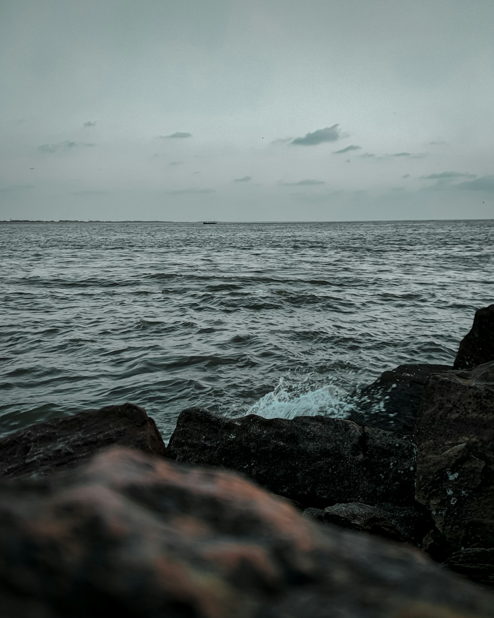 black and brown rock formation beside body of water during daytime