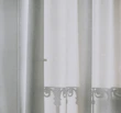 Elegant curtain and rod set framing a bright window, with soft fabric flowing gently in the breeze.