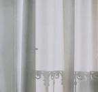 Elegant curtain and rod set framing a bright window, with soft fabric flowing gently in the breeze.