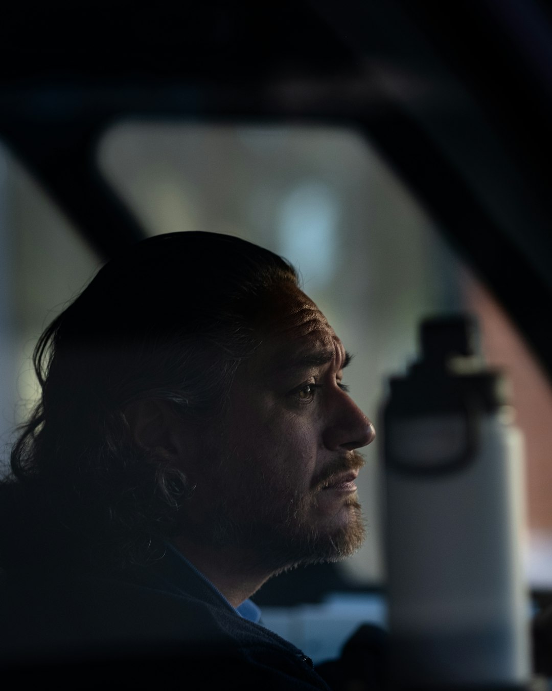 man in black shirt looking at the window