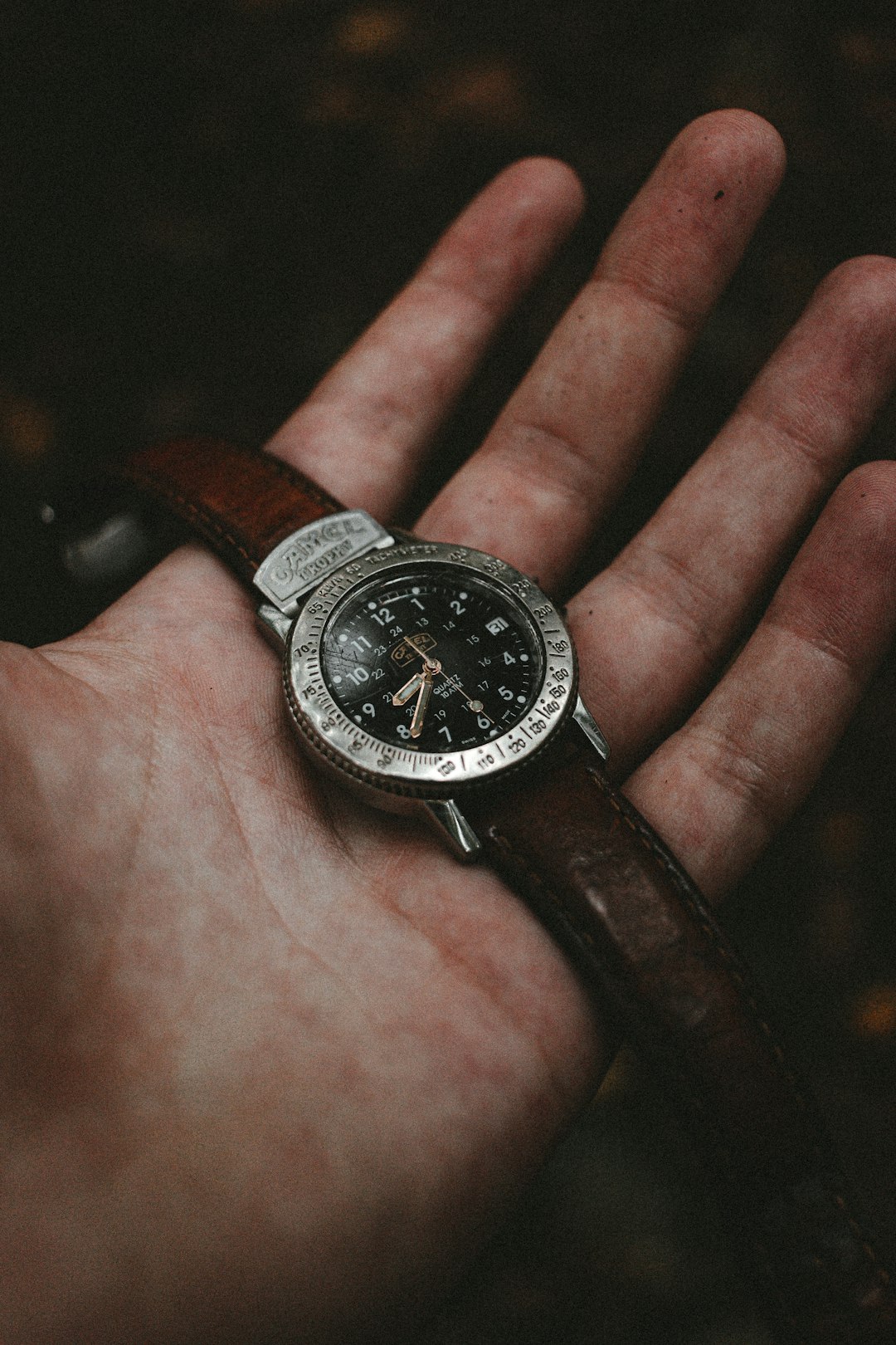 person holding silver round analog watch