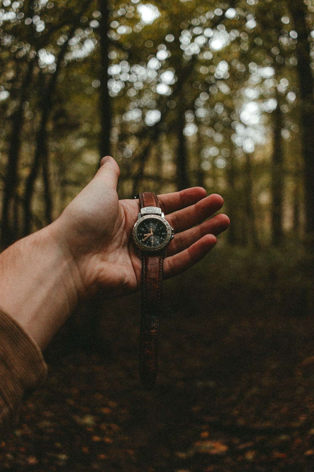 person holding silver and black round analog watch