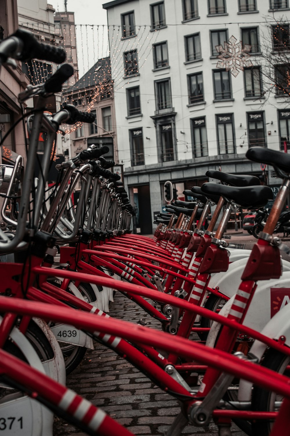 red and black bicycle parked on sidewalk during daytime