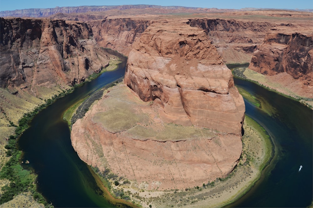 brown rock formation near green water