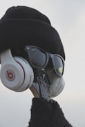 A creative visual of a guitar headstock dressed up with a hat, sunglasses, and headphones, giving it a human-like appearance.