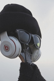 A creative visual of a guitar headstock dressed up with a hat, sunglasses, and headphones, giving it a human-like appearance.