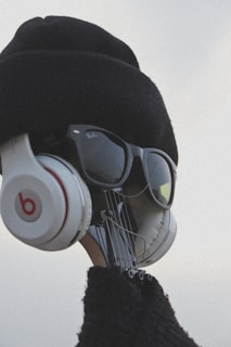 A creative visual of a guitar headstock dressed up with a hat, sunglasses, and headphones, giving it a human-like appearance.