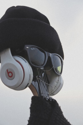 A creative visual of a guitar headstock dressed up with a hat, sunglasses, and headphones, giving it a human-like appearance.