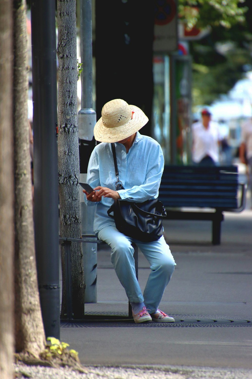 man in white dress shirt and black pants sitting on bench during daytime