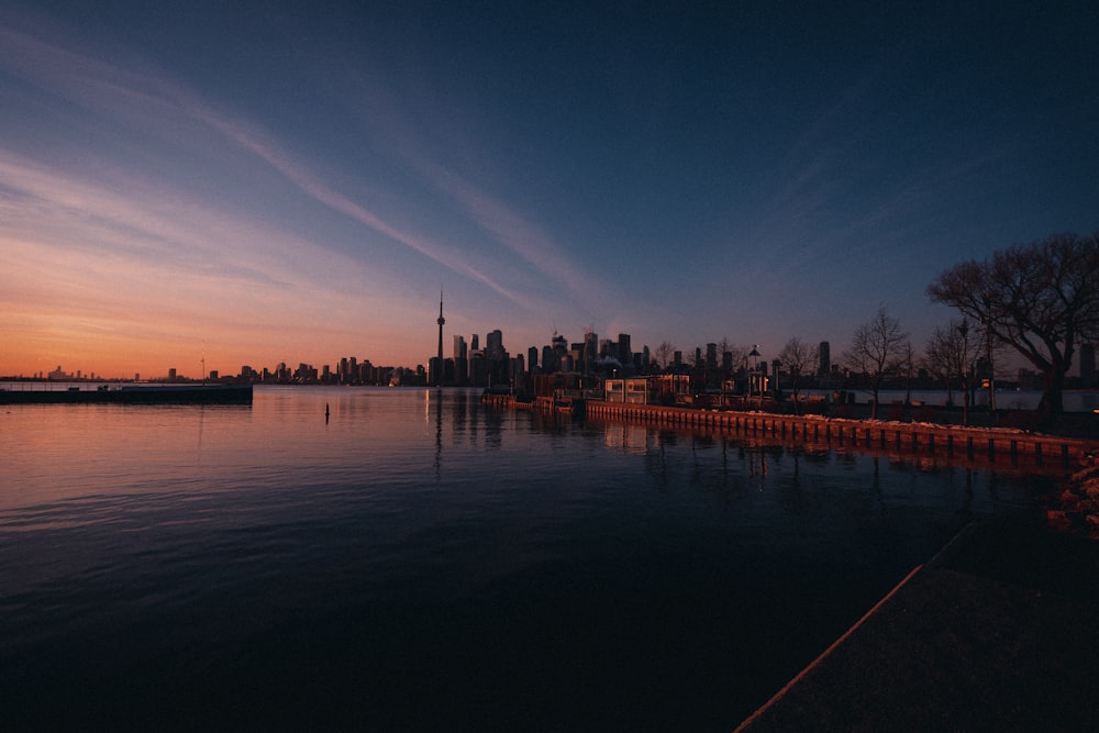 silhouette of bridge over body of water during sunset