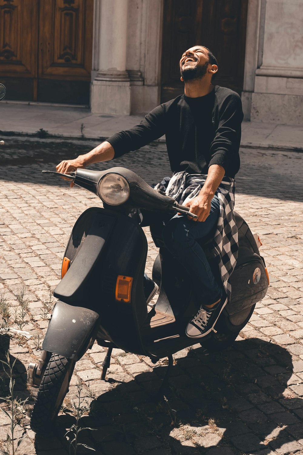 uomo in giacca di pelle nera in sella a moto nera