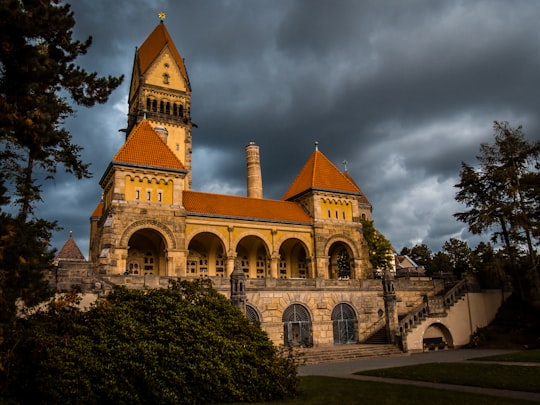 brown and white concrete building under cloudy sky during daytime in Südfriedhof Germany