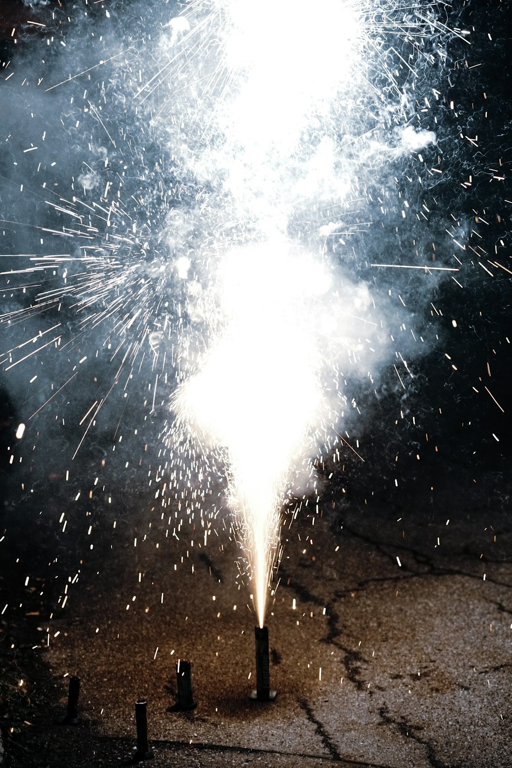 white fireworks on brown sand during night time
