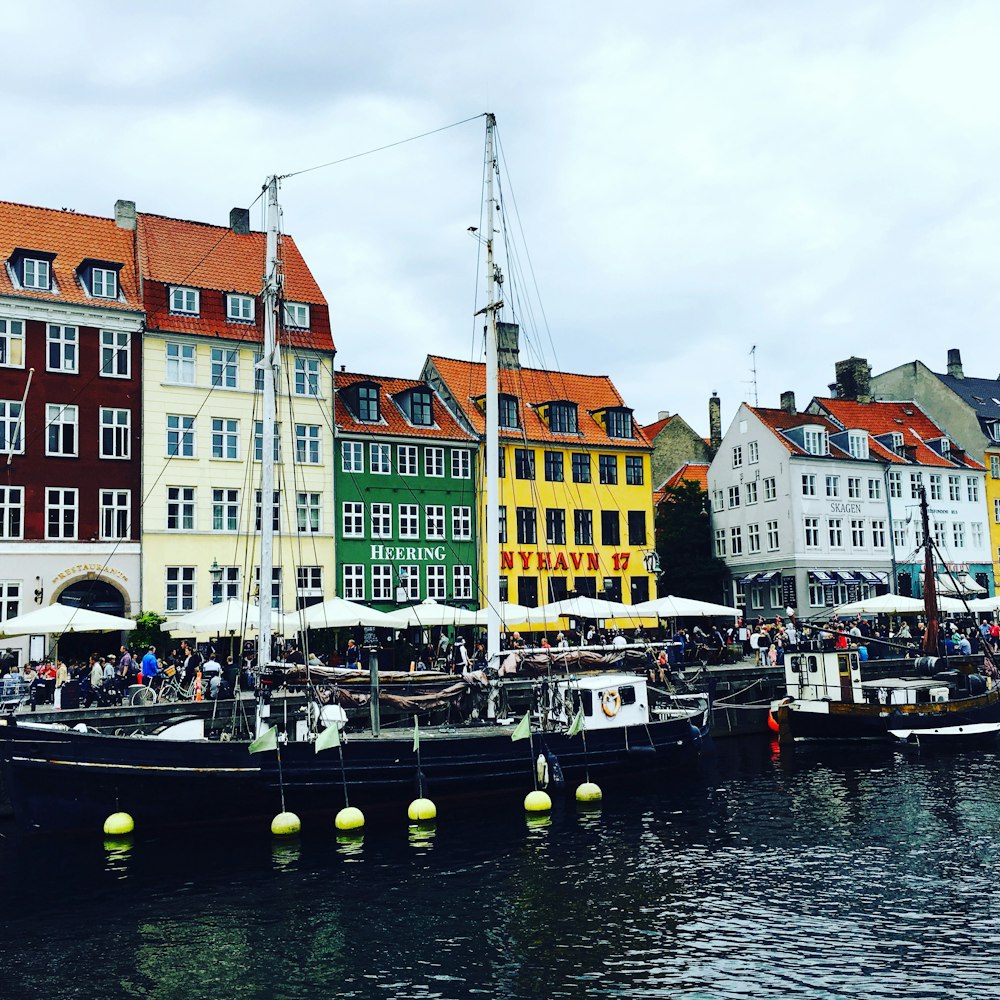 boat on dock near buildings during daytime