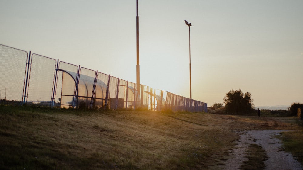 brown wooden fence near green grass field during daytime