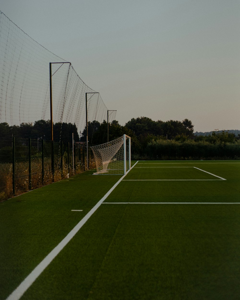 soccer goal net on green grass field during daytime
