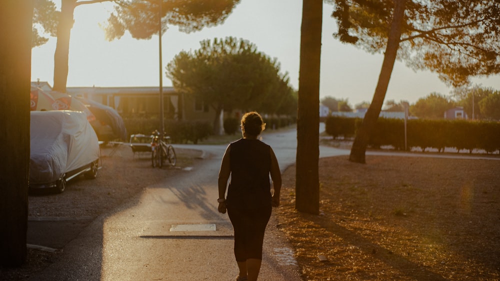 man in black jacket walking on sidewalk during daytime