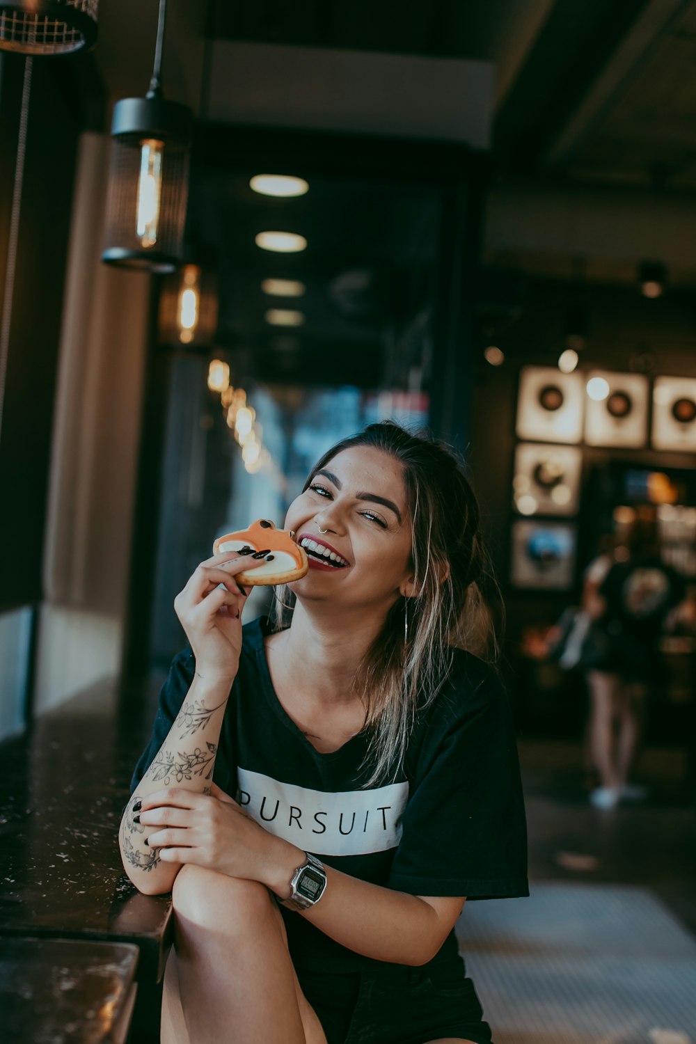 woman in black and white shirt holding orange fruit