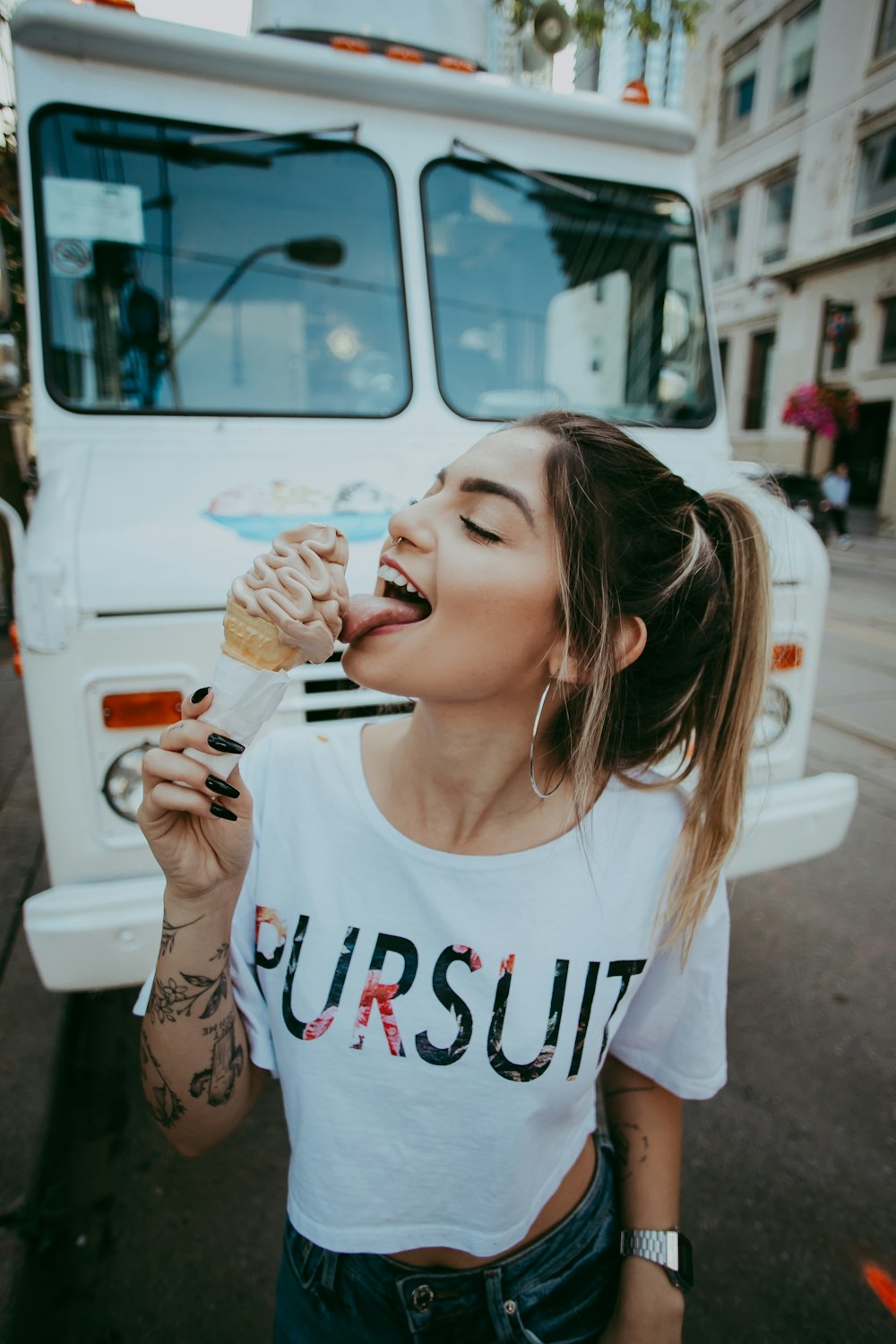 woman in white and red crew neck shirt eating ice cream