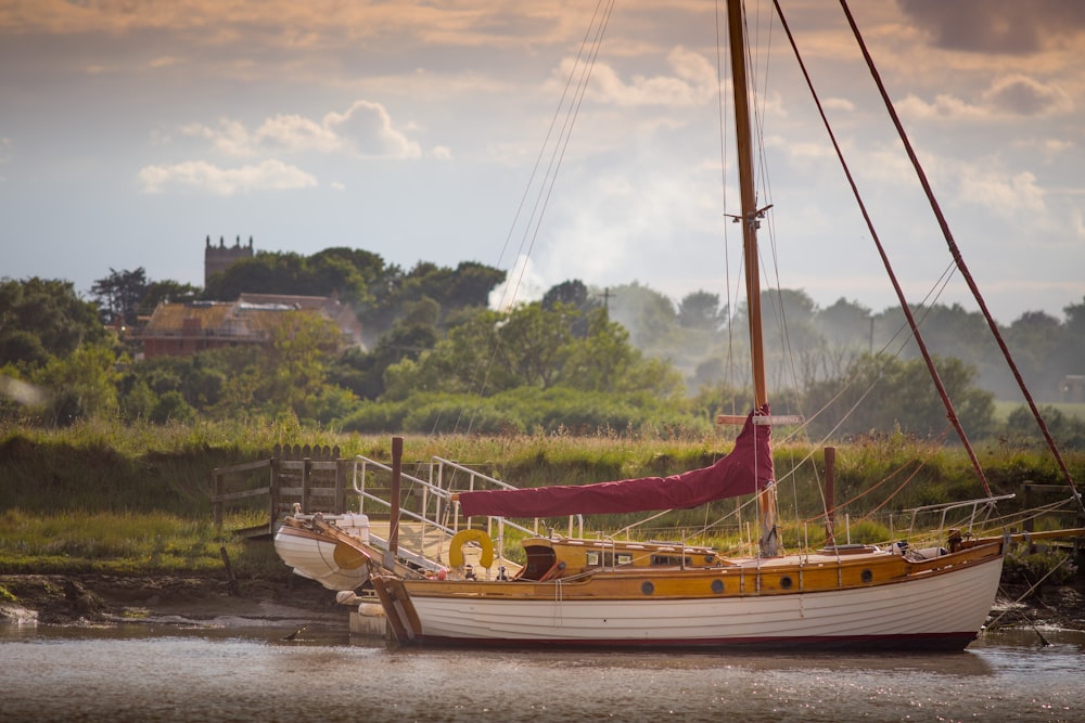 brown and white boat on body of water during daytime