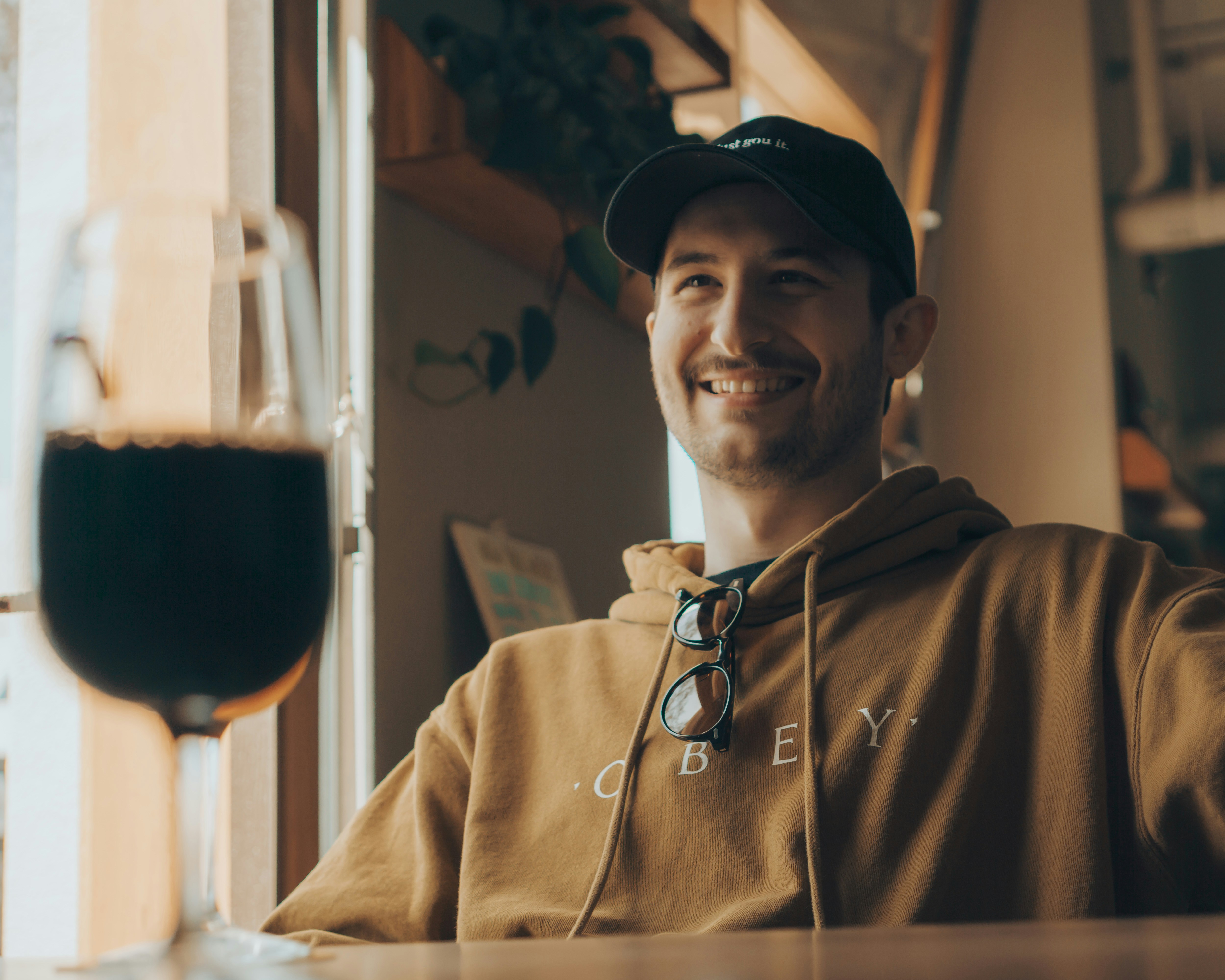man in brown hoodie wearing black cap