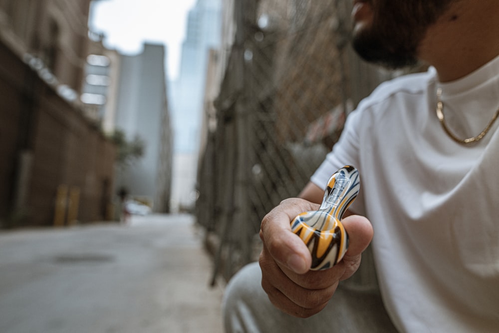 person in white long sleeve shirt holding yellow and black plastic toy car