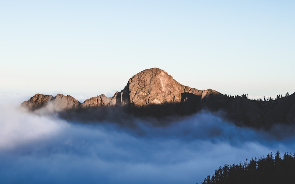 brown rocky mountain under white clouds during daytime