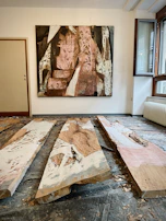 A bright abstract painting hanging on a white wall with soft natural light.