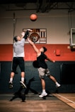 man in gray t-shirt and black pants holding basketball