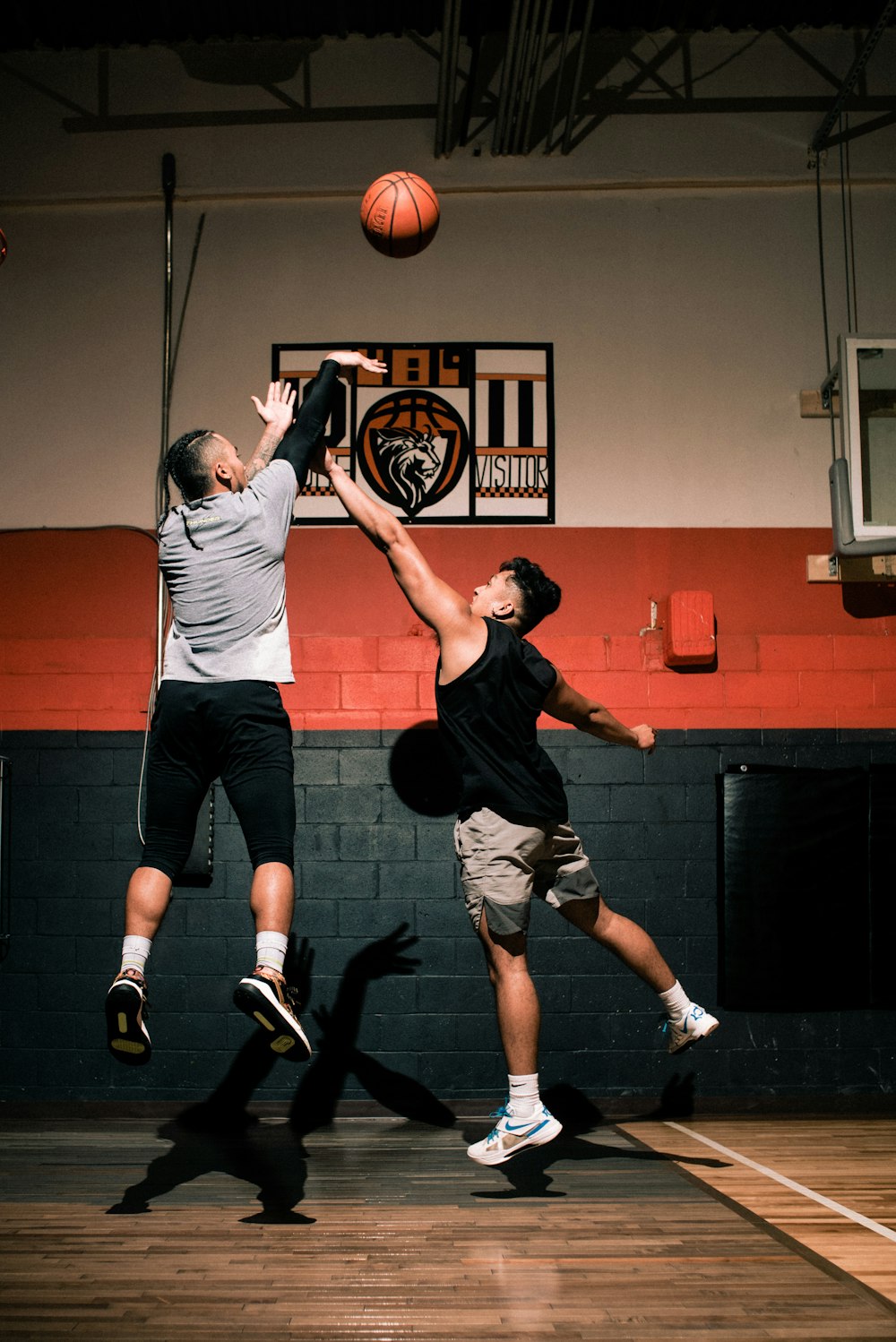 man in gray t-shirt and black pants holding basketball