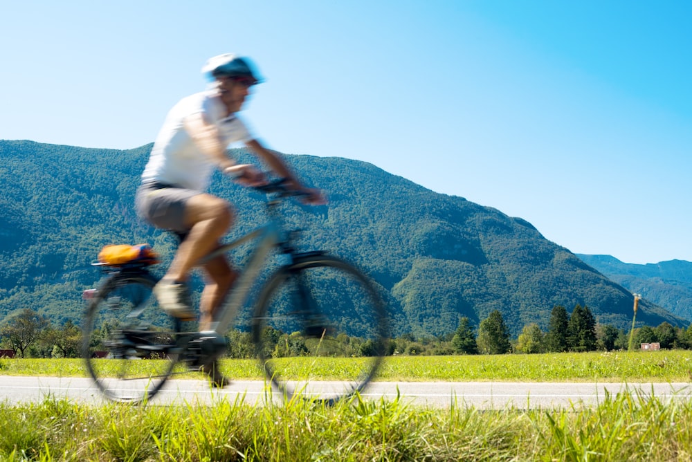 man in white shirt riding on black mountain bike during daytime