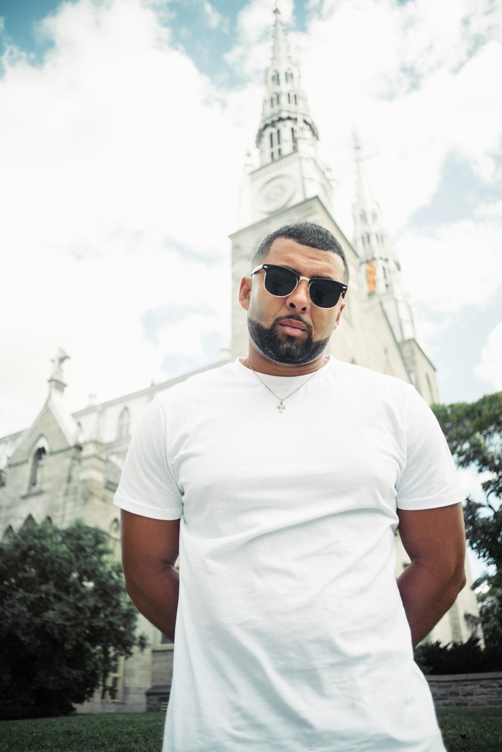 man in white crew neck t-shirt wearing gold framed aviator sunglasses