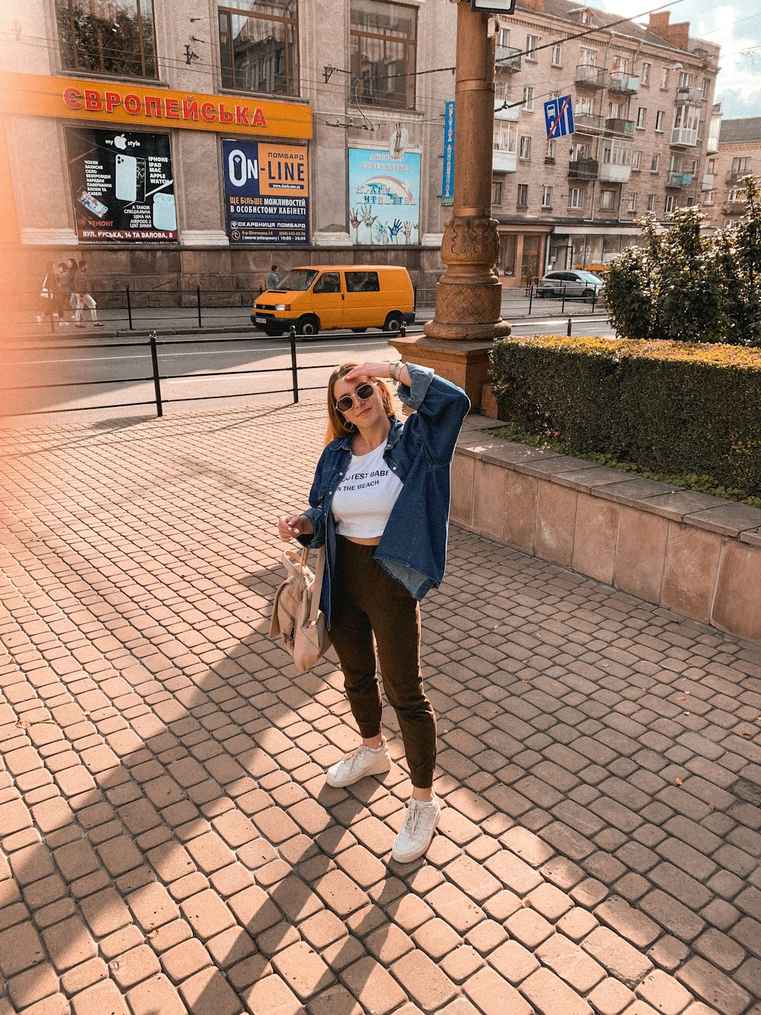 woman in blue denim jacket and black pants holding brown dog