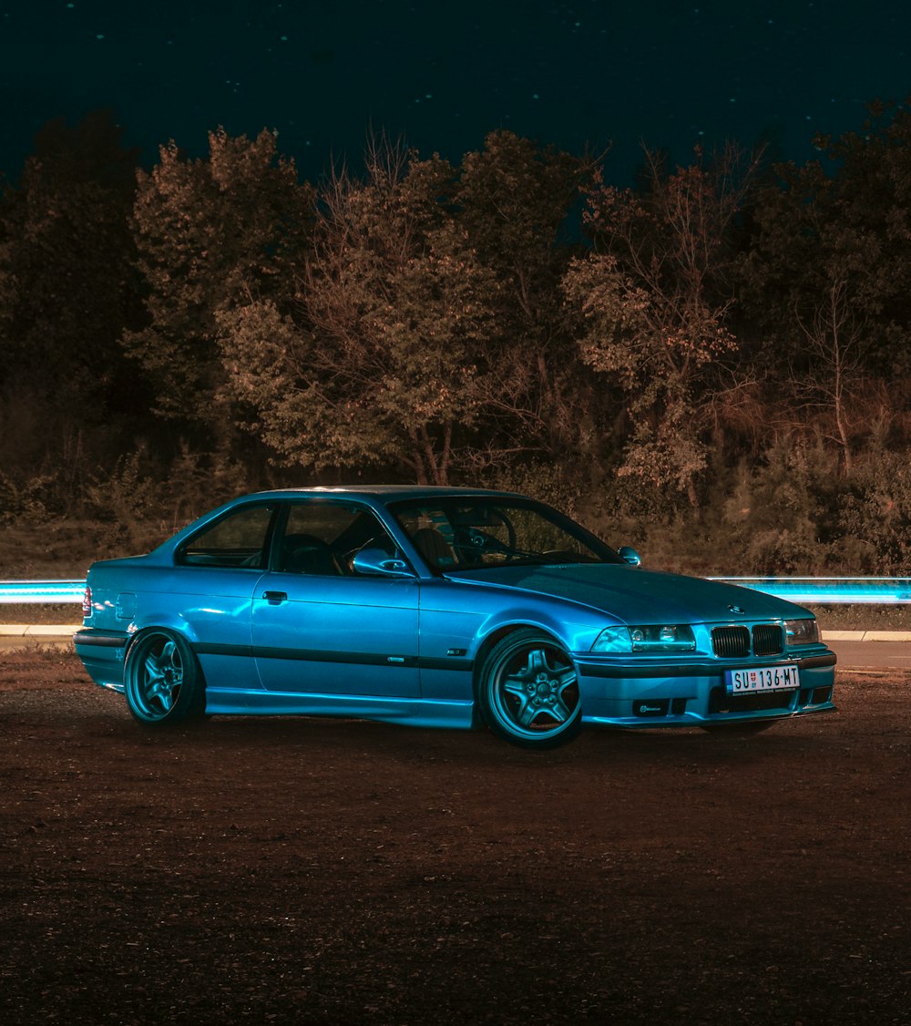 blue sedan on gray asphalt road during daytime