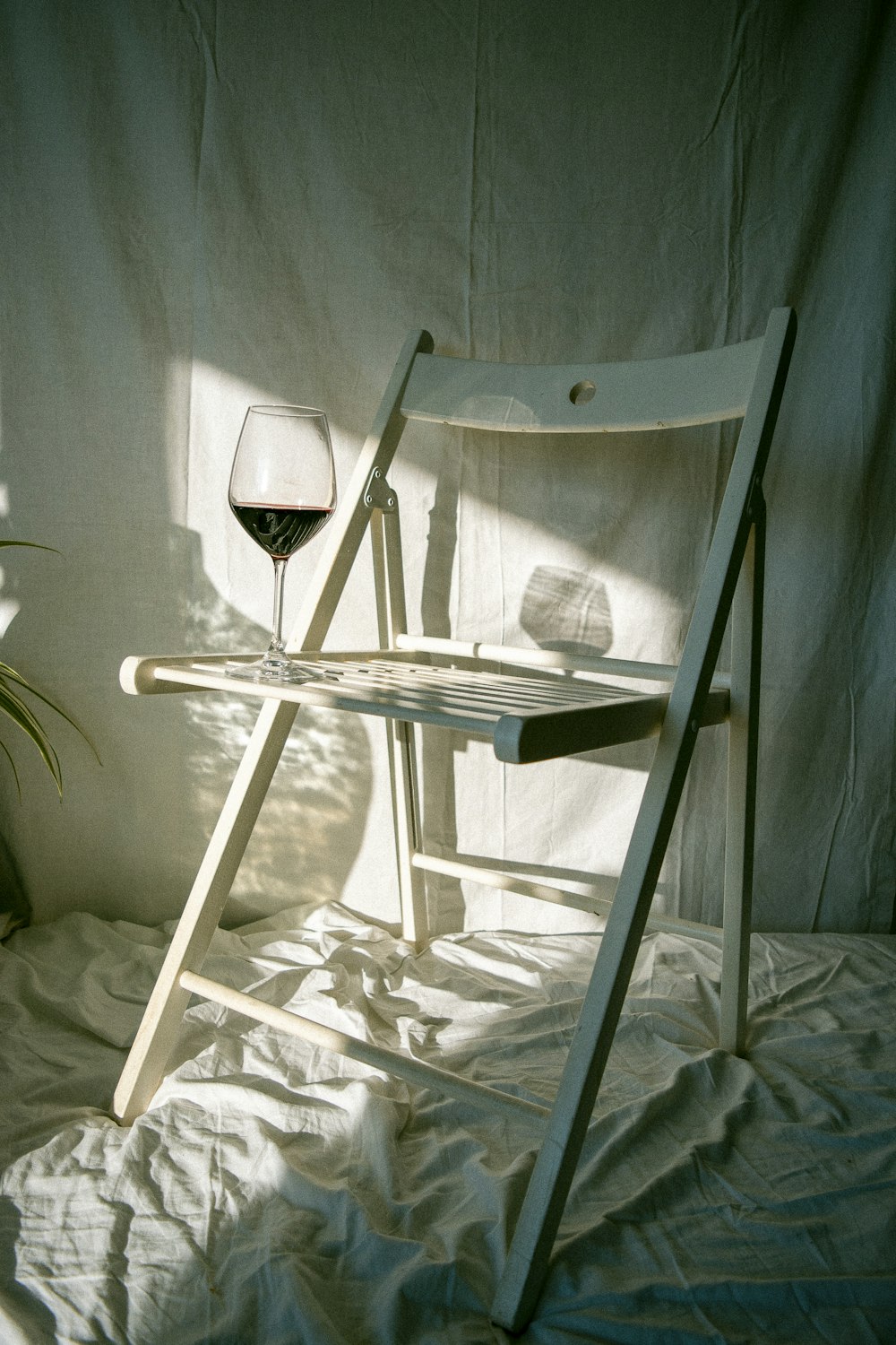 white folding chair on white bed