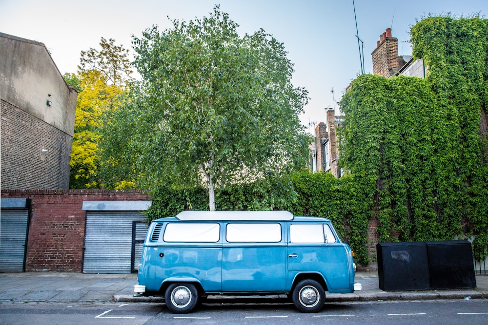blue volkswagen t-2 parked near green trees during daytime