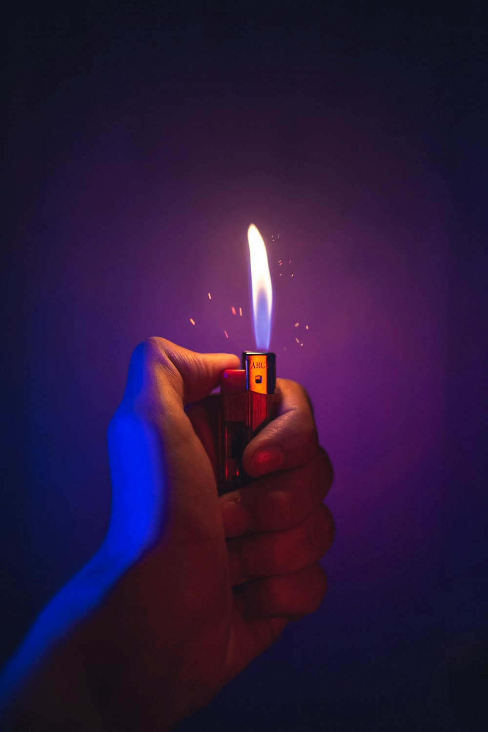 person holding lighter with blue light