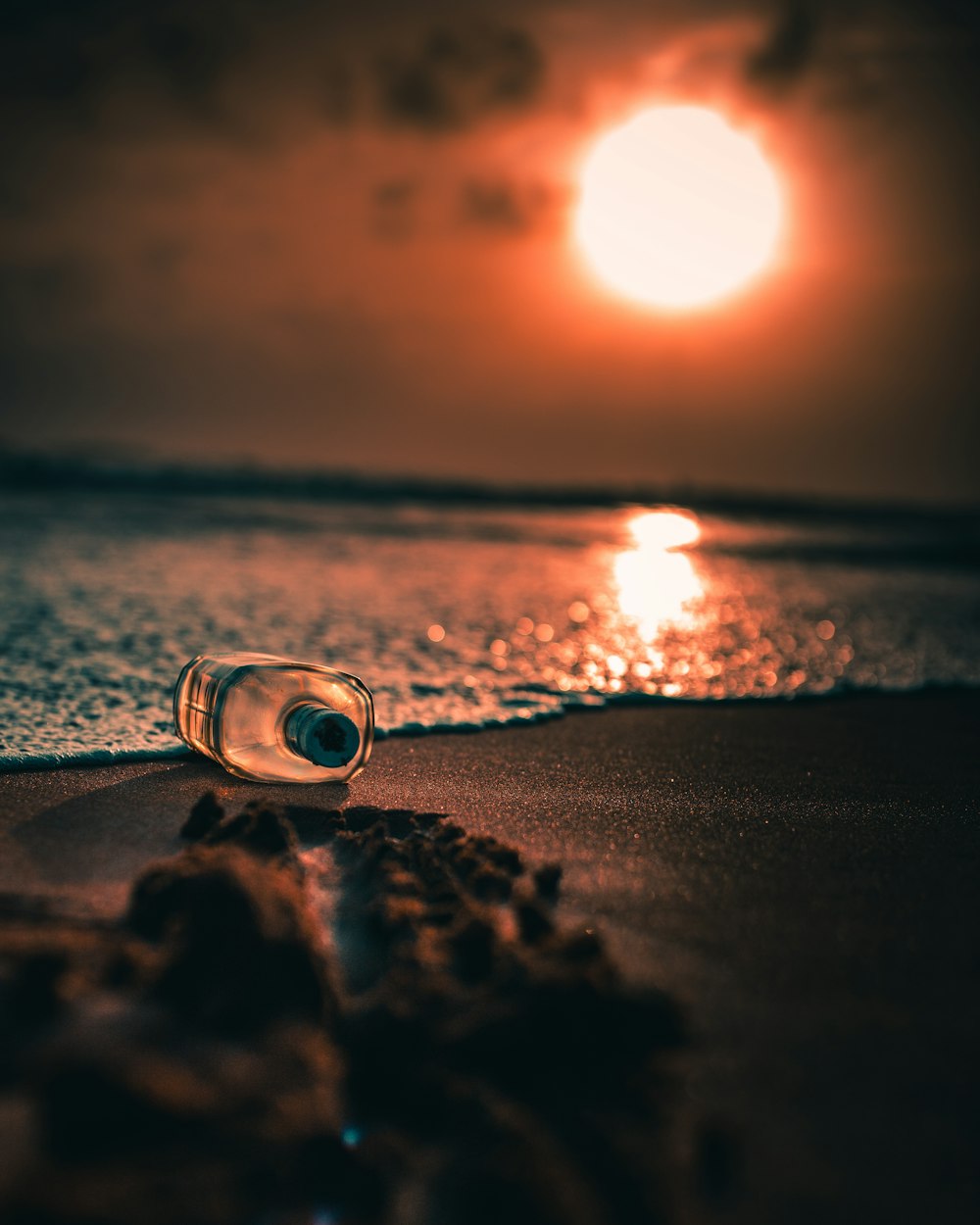 clear glass candle holder on beach shore during sunset