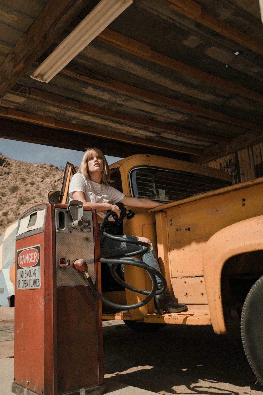 woman in black and white long sleeve shirt sitting on orange truck