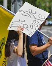 man in blue crew neck t-shirt holding white printer paper