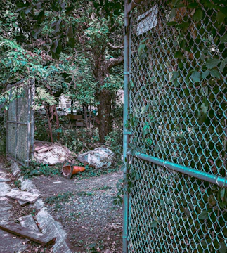 Installation of a green military-colored cyclone mesh fence around a small business perimeter