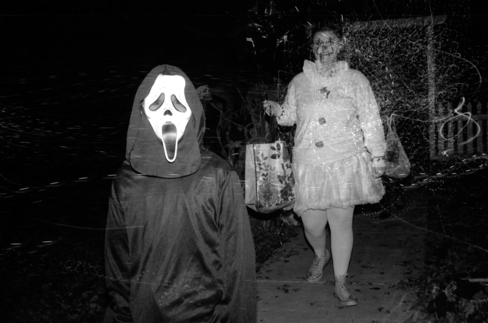 man and woman standing beside white skull