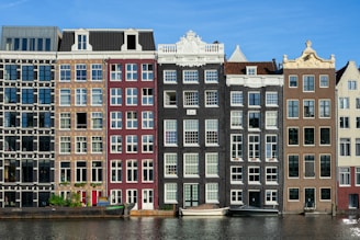 brown and white concrete building near canals in Amsterdam Netherland